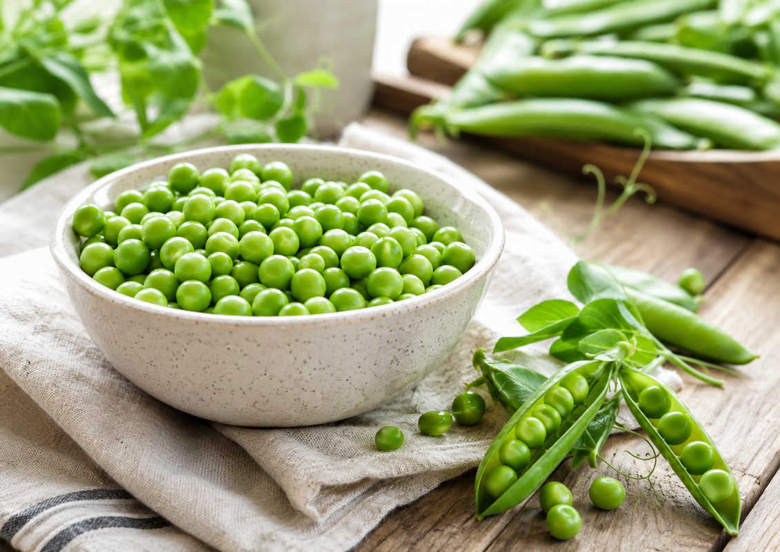 piselli-proprieta-valori-nutrizionali.jpg Piselli verdi freschi e baccelli pronti per essere cucinati