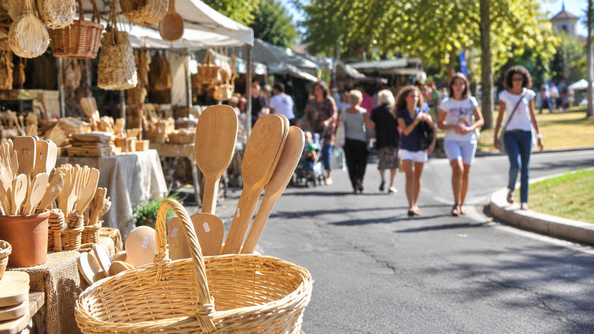 Mestoli e utensili in legno alla Fiera del Mestolo di Arezzo, con visitatori tra le bancarelle